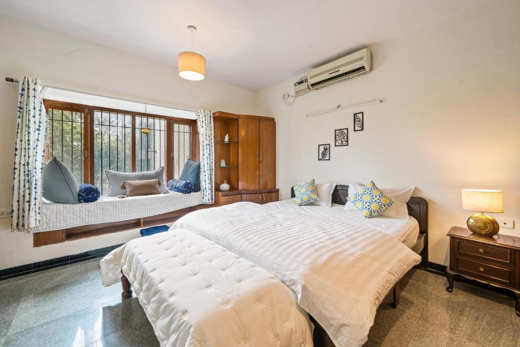 una camera da letto con un grande letto bianco e una finestra di Cedar-Golf Course View a Bangalore