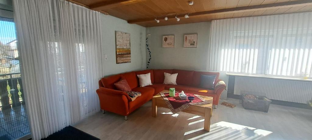a living room with a red couch and a table at Ferienwohnung Giengen in Giengen an der Brenz