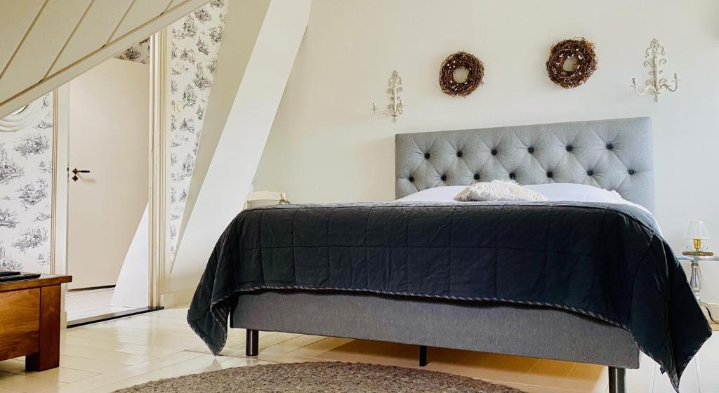 een slaapkamer met een bed met een grijs hoofdeinde bij 't Heerenhuys in Wageningen