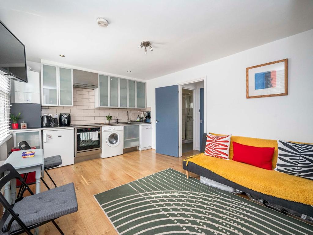 a living room with a couch and a kitchen at Newly renovated by British Museum - Pass the Keys in London