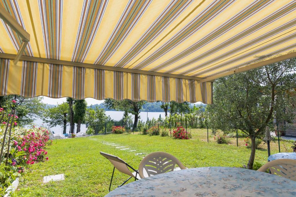 stół i krzesła pod parasolem patio w obiekcie Casa Maddalena Private Beach on request - Happy Rentals w mieście Cadrezzate