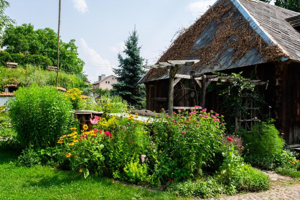 un giardino fiorito di fronte a una casa di Letnisko Sikory a Sikory