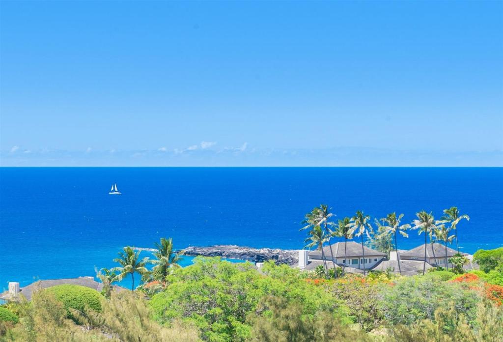 a boat in the blue ocean with palm trees at 622 Kapalua Ridge Villa in Kahana