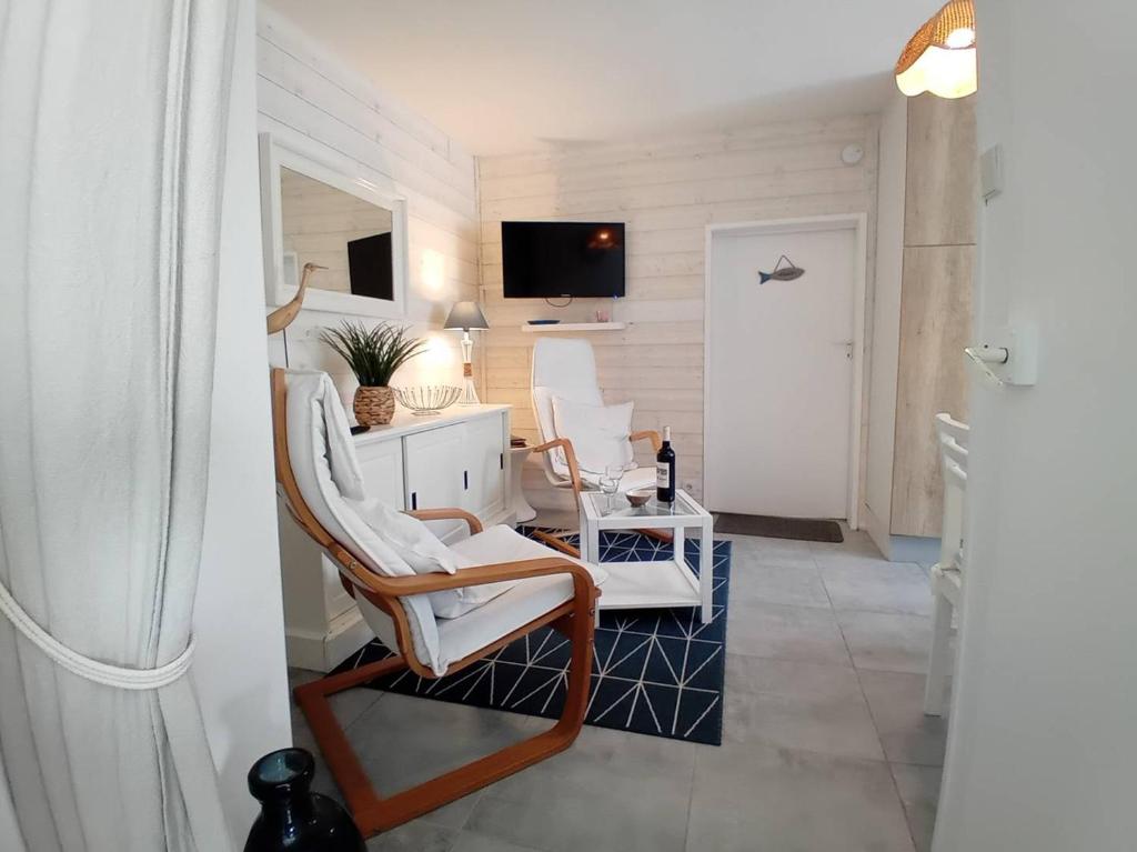 un salon avec deux chaises et une télévision dans l'établissement Saint Georges de Didonne - LA PLAGE A 2 PAS - idéal pour un COUPLE avec ENFANTS, à Saint-Georges-de-Didonne