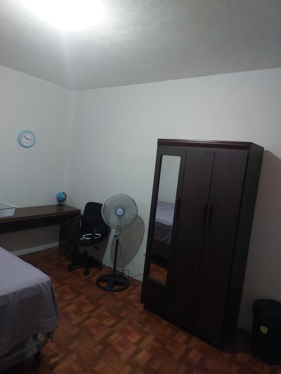 um quarto com um armário preto e uma ventoinha em Cómodo apartamento em Amatitlán