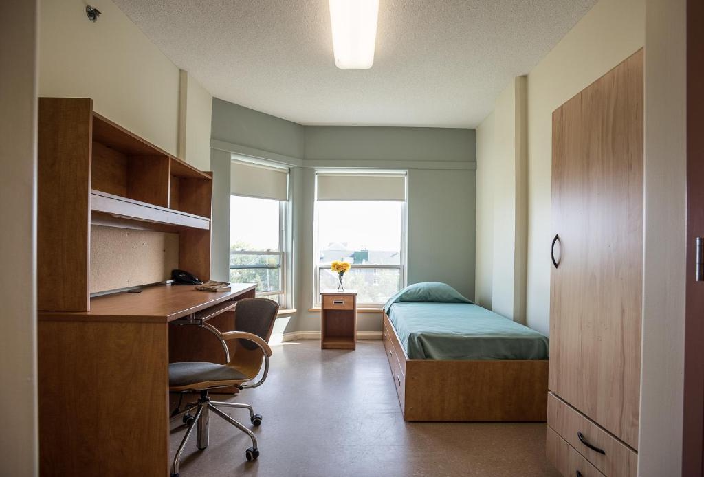a bedroom with a desk and a bed and a desk at Mount Saint Vincent University in Halifax