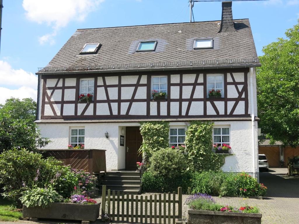 a house with flowers in front of it at Gästehaus Bauernstube in Irmenach