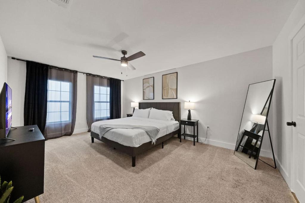 een slaapkamer met een bed en een televisie. bij Spacious 6 Bed House near Airport, Pet-Friendly, Close to AFB in San Antonio