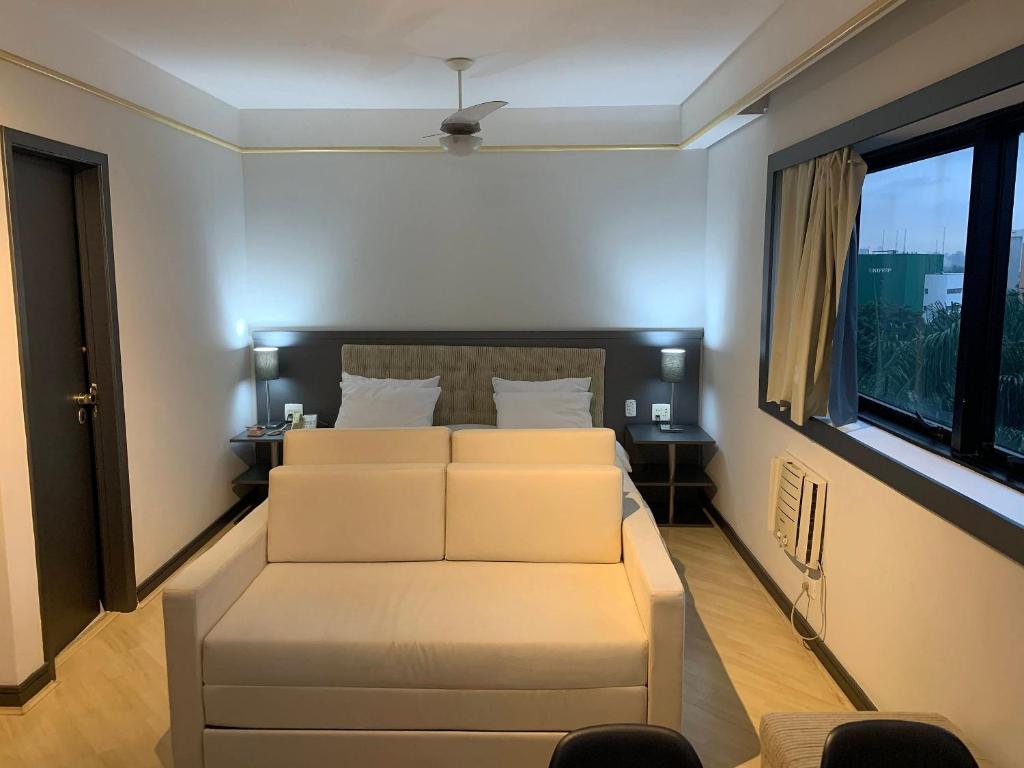 a living room with a white couch and a window at Get a Flat - 703 Luxo e Conforto - Ibirapuera in São Paulo