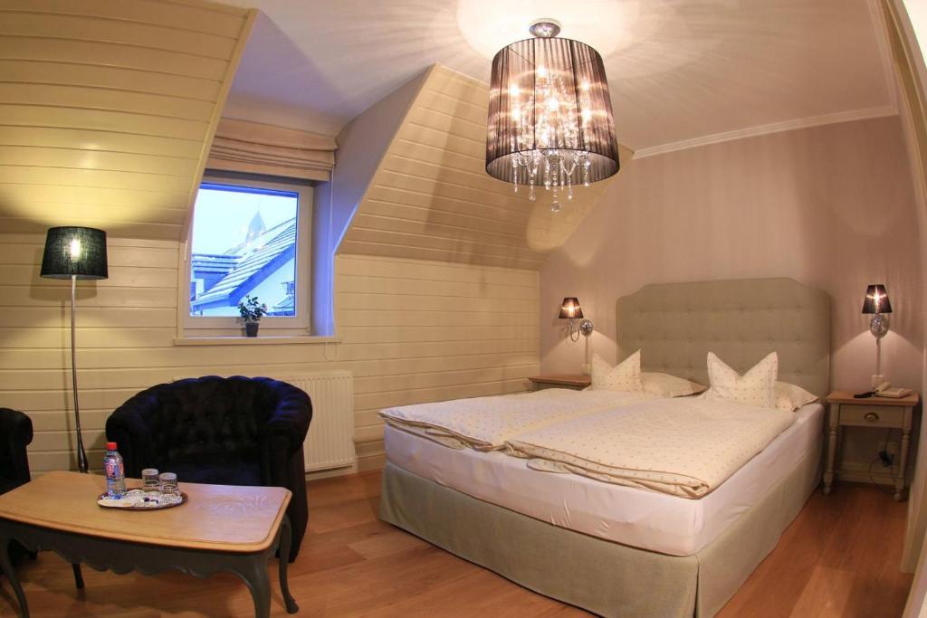 a bedroom with a bed and a table and a chair at Hotel Eifelland in Butgenbach