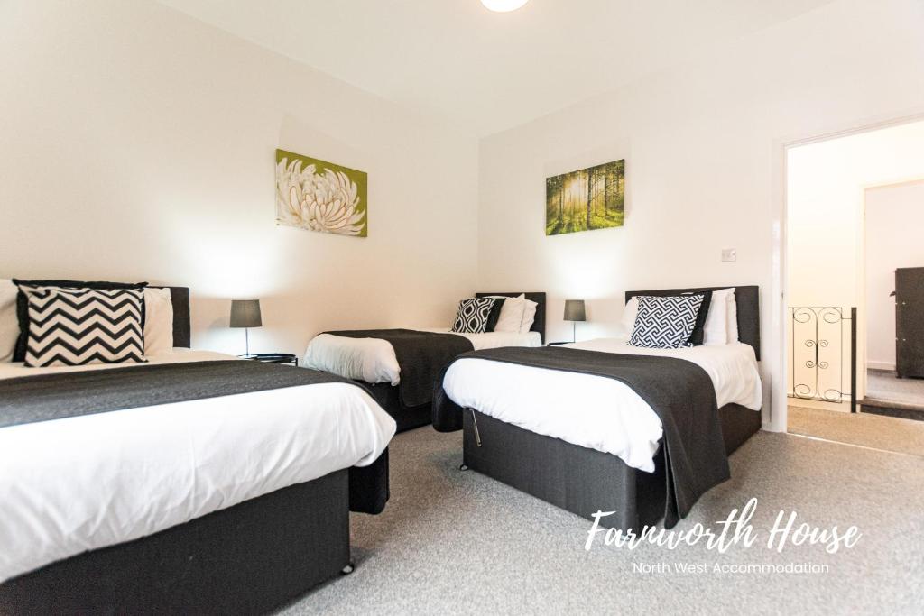 drie bedden in een kamer met witte muren bij Farnworth Contractor Accommodation in Farnworth