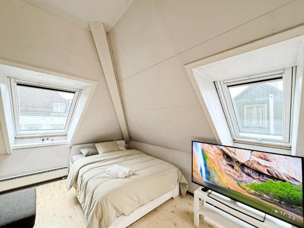 a bedroom with a bed and a flat screen tv at City View & Central Location in Trondheim