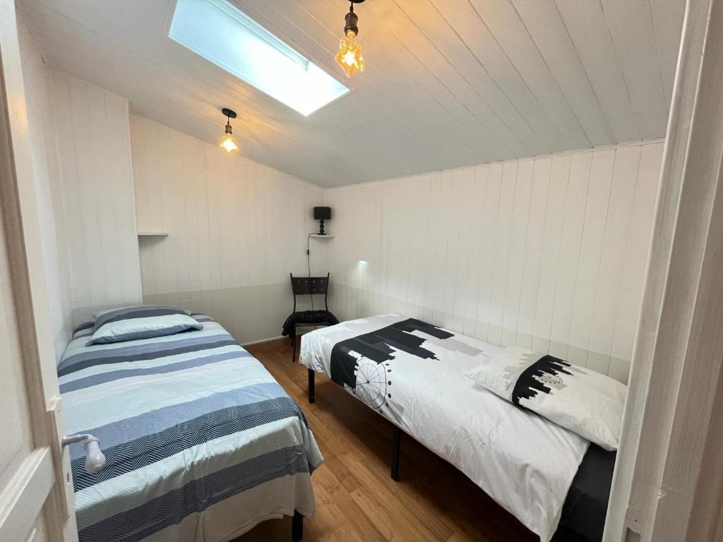 a bedroom with two beds and a skylight at Chez Jean-Jean in Chantonnay