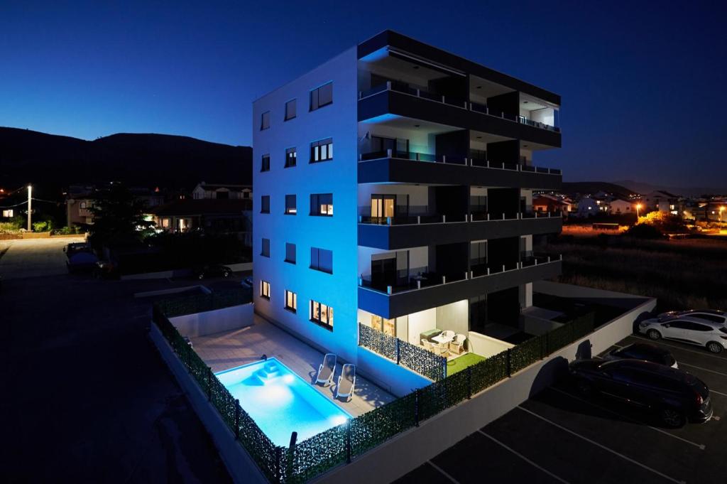 a building with a swimming pool at night at Sore in Trogir