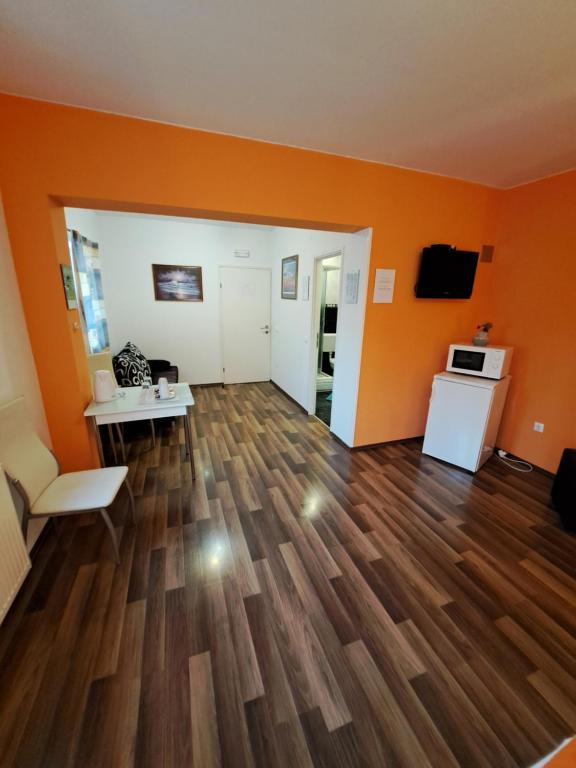 an empty living room with orange walls and wooden floors at Rooms Modrušan in Slunj
