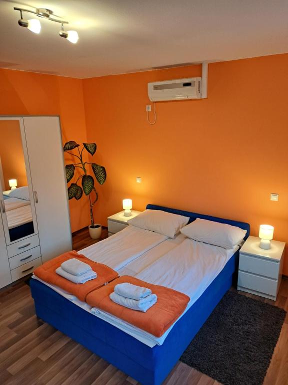 1 dormitorio con 1 cama grande y paredes de color naranja en Rooms Modrušan, en Slunj