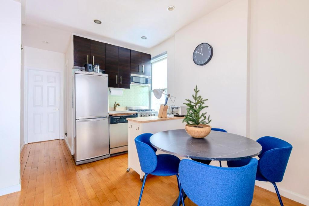 a kitchen with a table and chairs and a refrigerator at Stylish and Cozy 2BD apartment in New York
