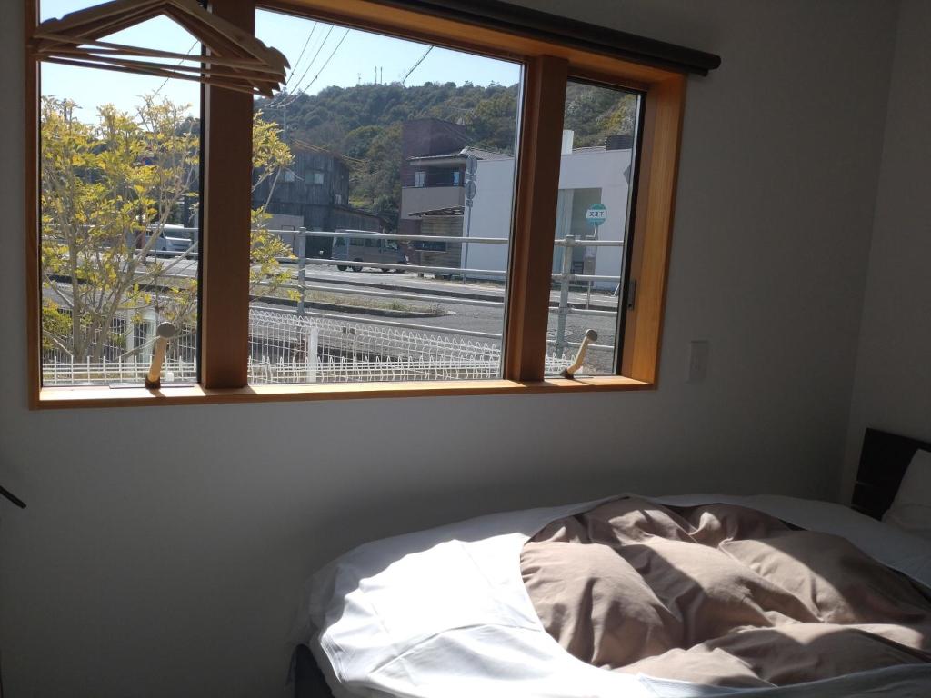 1 dormitorio con cama y ventana con vistas en Naoshima Accommodation Menjuku Ura - Vacation STAY 25585v, en Naoshima