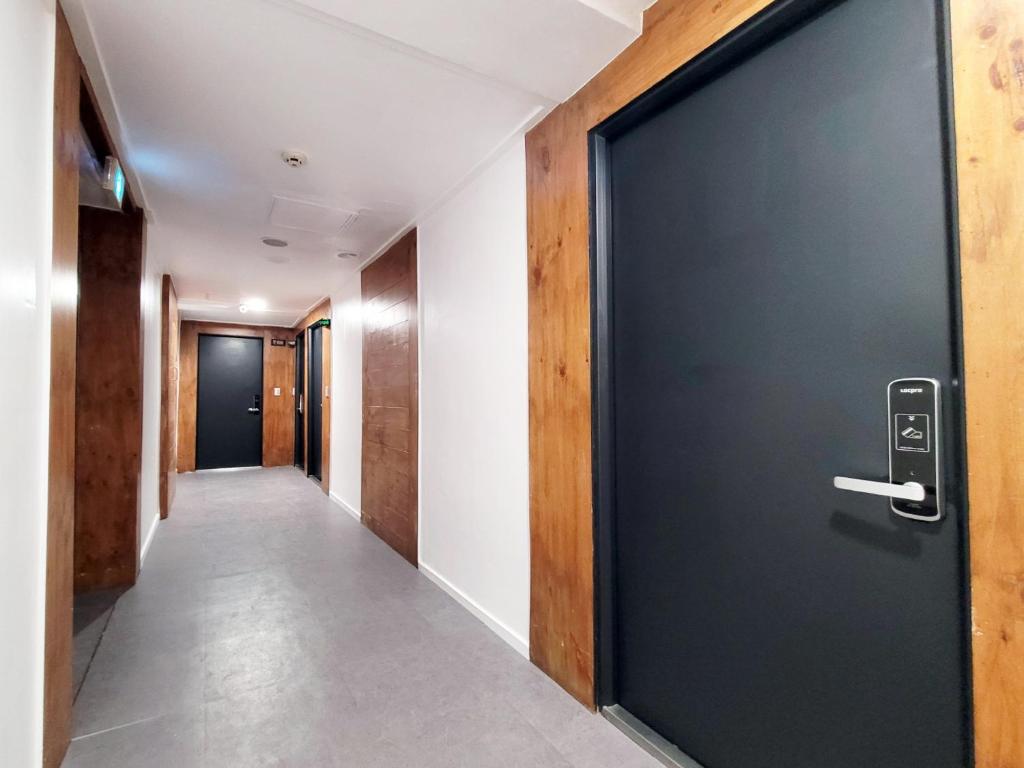 a hallway with a black door and a hallway with a corridorngthngthngthngth at Residence Yeoyu in Guri