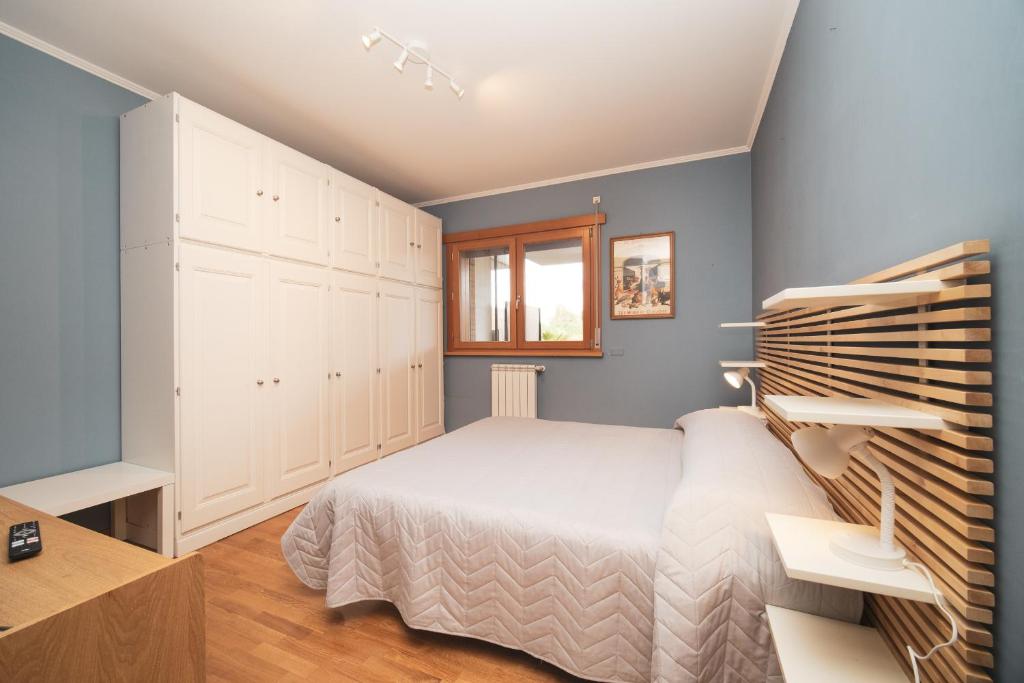 um quarto com uma cama branca e paredes azuis em Borghetto Vara by BuddyRent em Roma