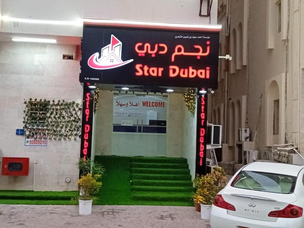 um carro estacionado em frente a uma placa de uma loja em Star Dubai Apartment em Salalah