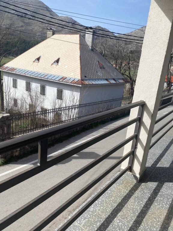 un balcón con una casa blanca y una valla en Kadmi en Njeguši
