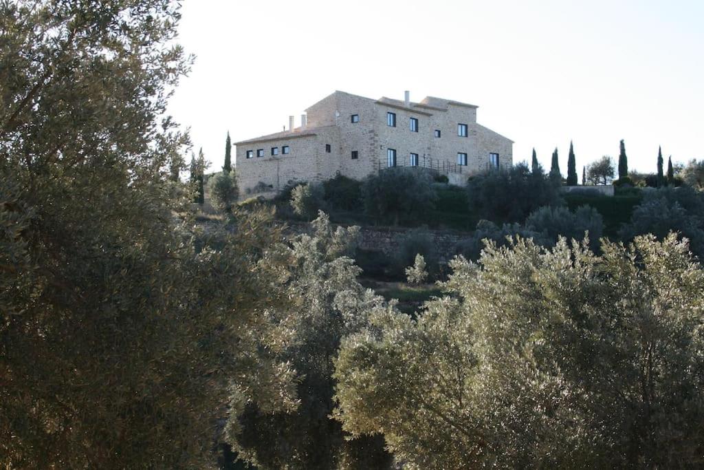 a building on top of a hill with trees at Luxurious secluded villa in Calaceite