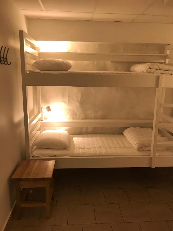 a room with bunk beds with a table and a bench at Hostel Dalagatan in Stockholm