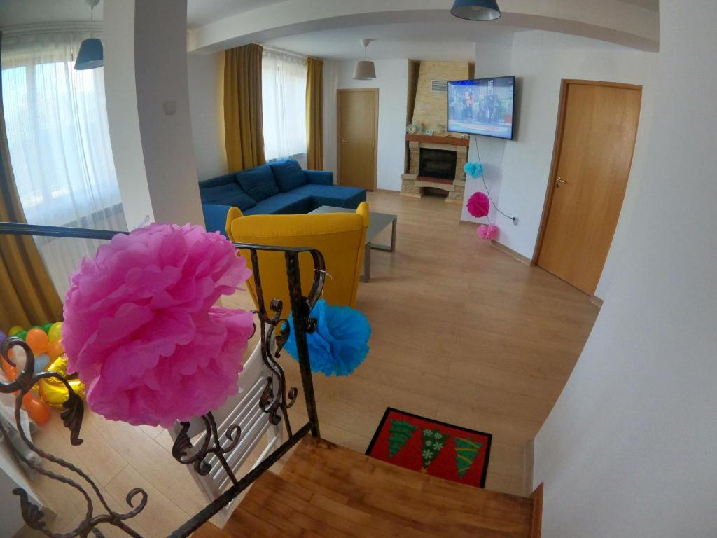 een woonkamer met een blauwe bank en roze ballonnen bij Casa Bear Azuga in Azuga