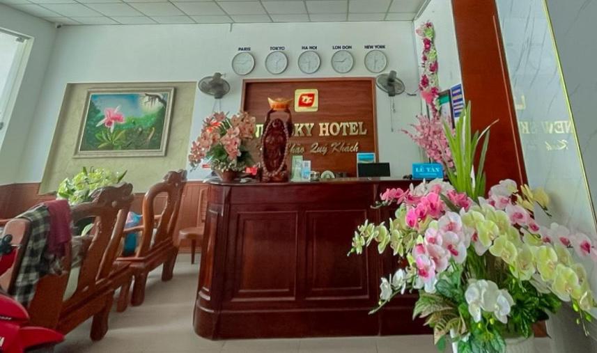 uma sala de espera com flores sobre uma mesa e cadeiras em New Sky Hotel em Dong Quan