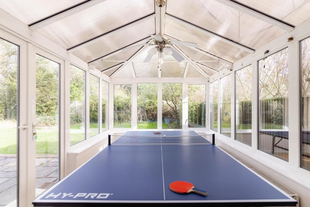 a pool table in a conservatory with windows at Ping-Pong Paradise in Crawley