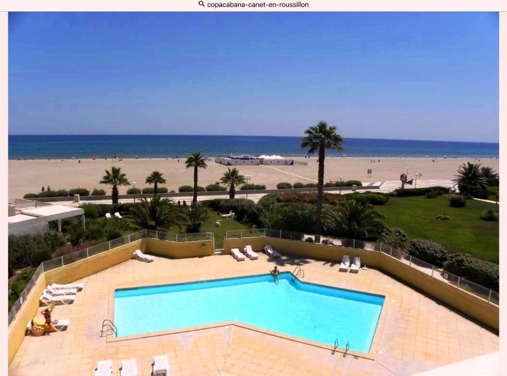 une piscine avec la plage en arrière-plan dans l'établissement COPACABANA, à Canet