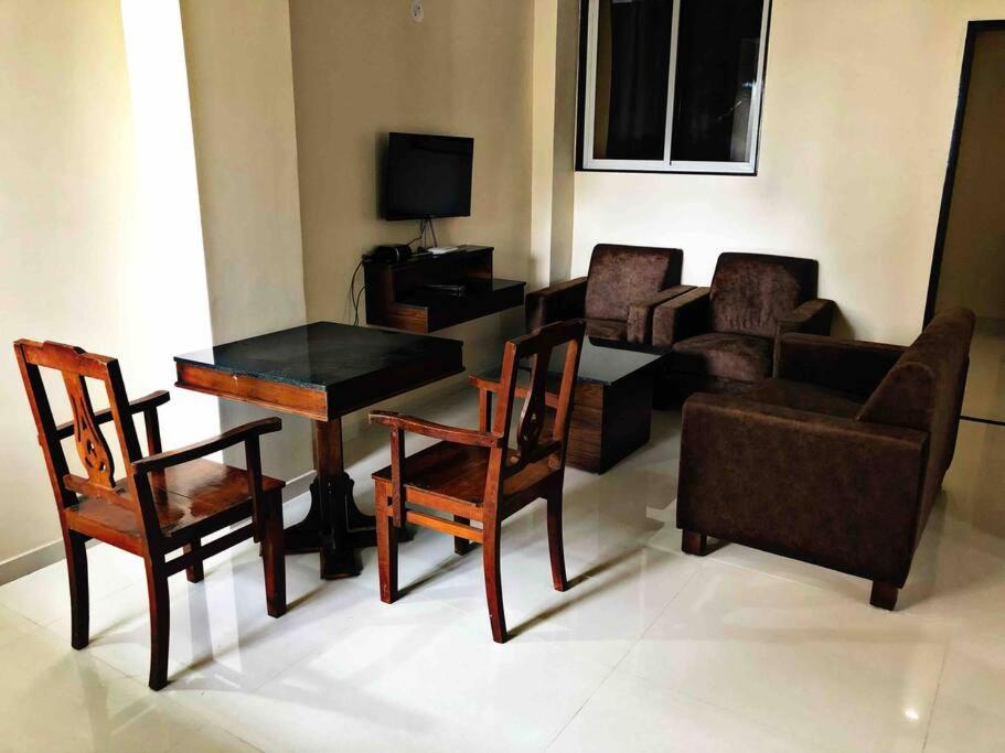 a living room with a table and chairs and a couch at SKYLARK STUDIO 2 in Belgaum