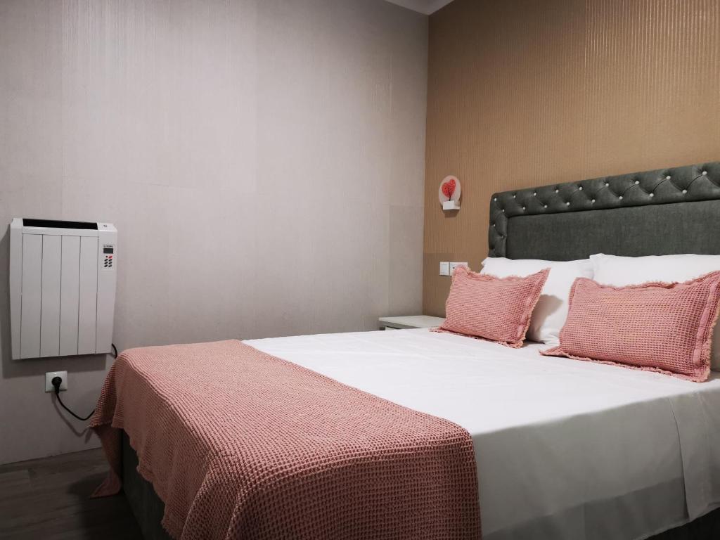 a bedroom with a large bed with pink pillows at Apartamento MS in Campo Maior
