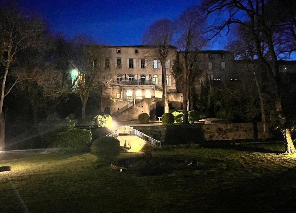 a building at night with a fountain in front of it at Le Domaine de Villespy in Villespy