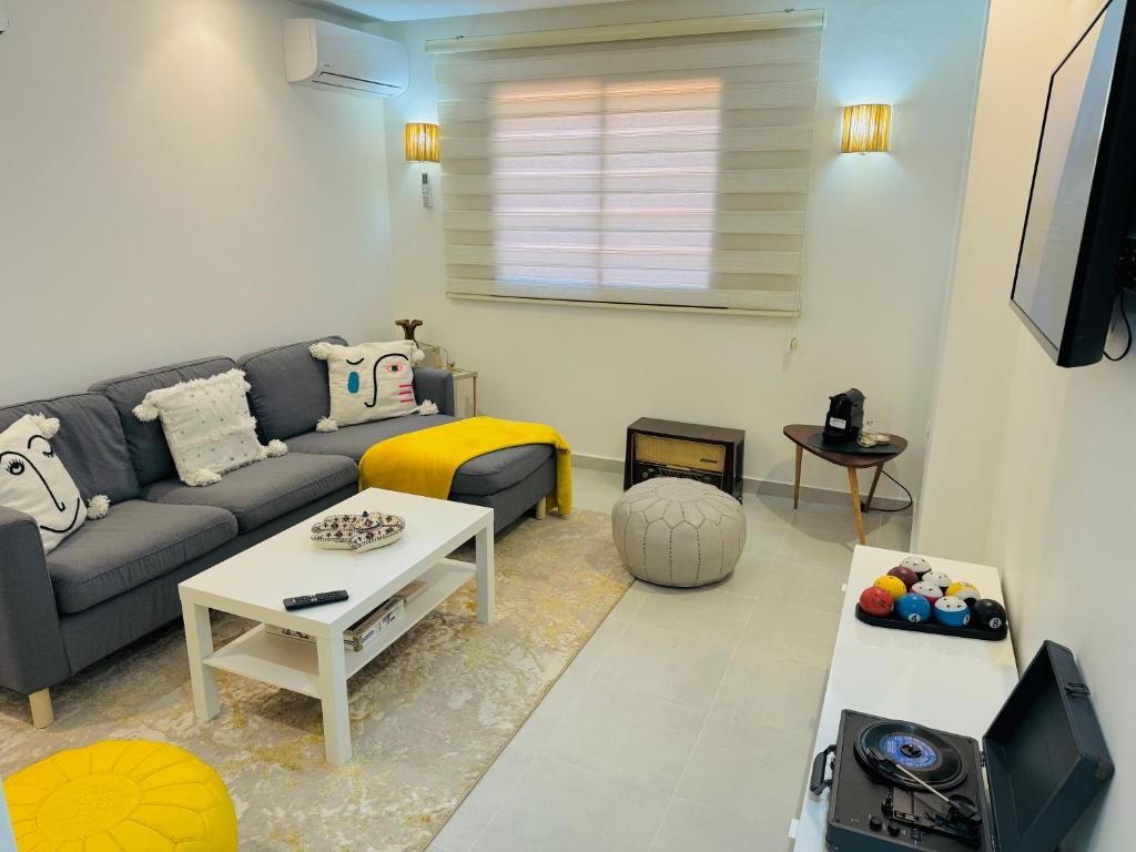 Le Majorelle Cozy Flat في مراكش: غرفة معيشة مع أريكة وطاولة