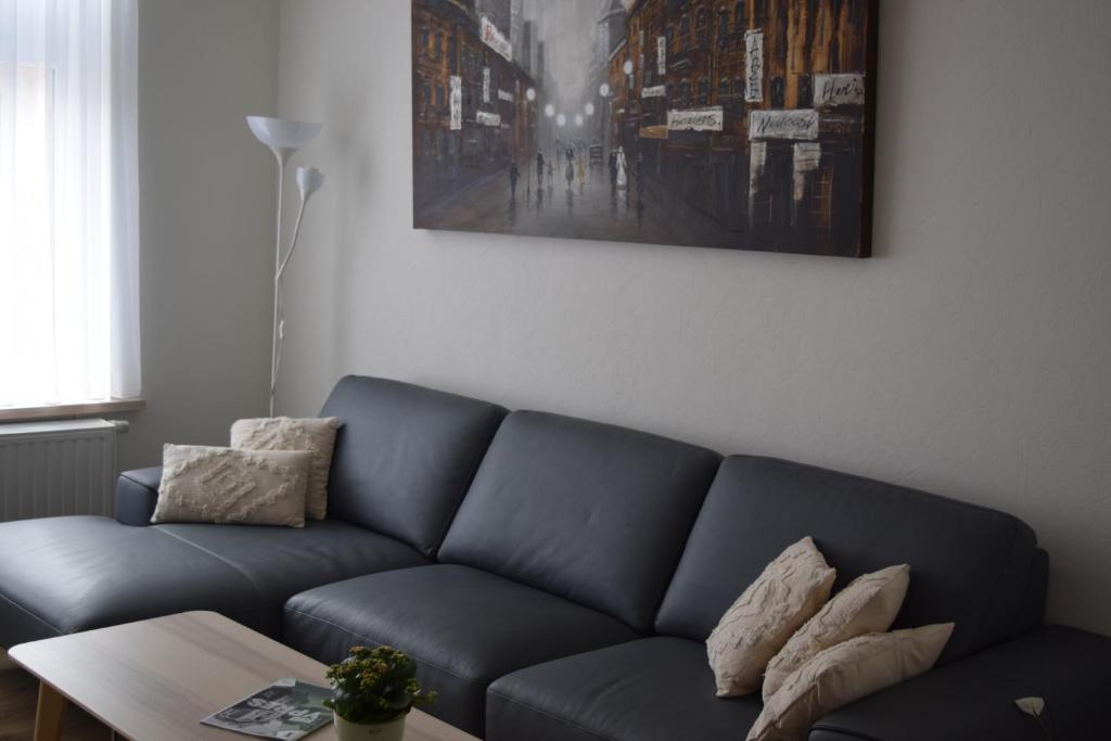 sala de estar con sofá azul y mesa en Apartment Aurora, en Ypres