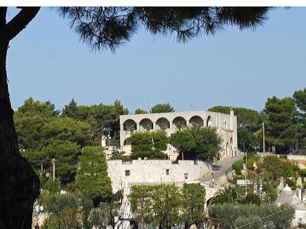 un edificio in cima a una collina con alberi di Hotel La Silvana a Selva di Fasano