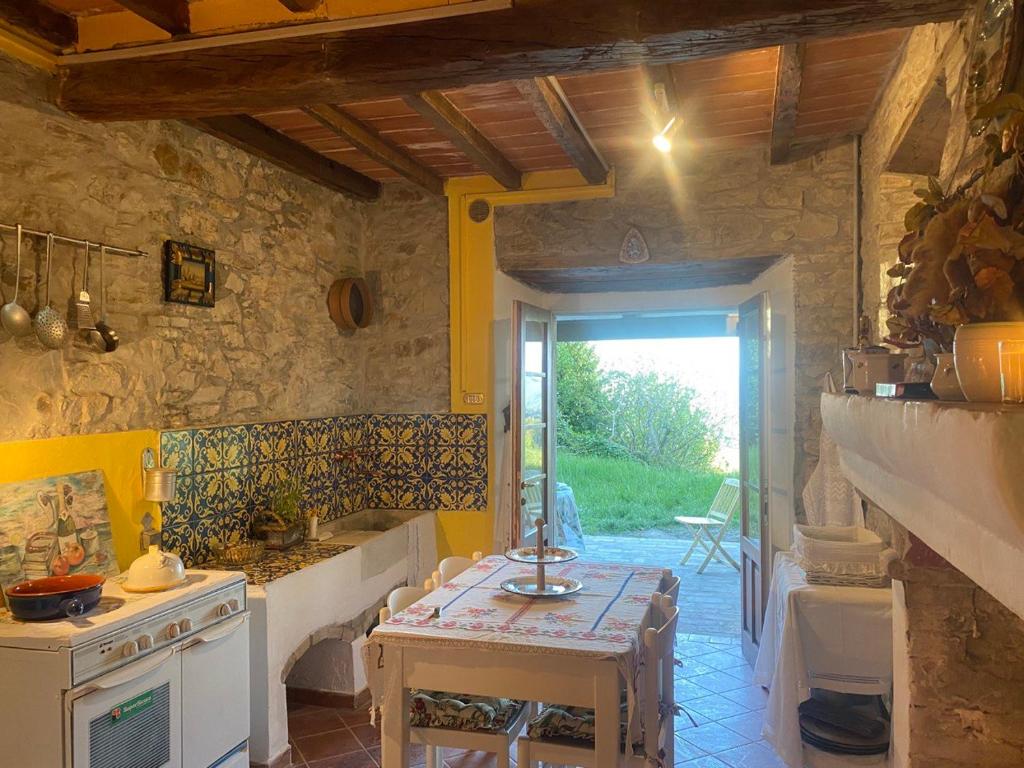 Villa Chicca في Neviano degli Arduini: مطبخ مع موقد وطاولة في الغرفة
