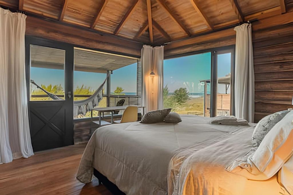 a bedroom with a bed with a view of the ocean at Villa Sayuri in Barra de Ibiraquera