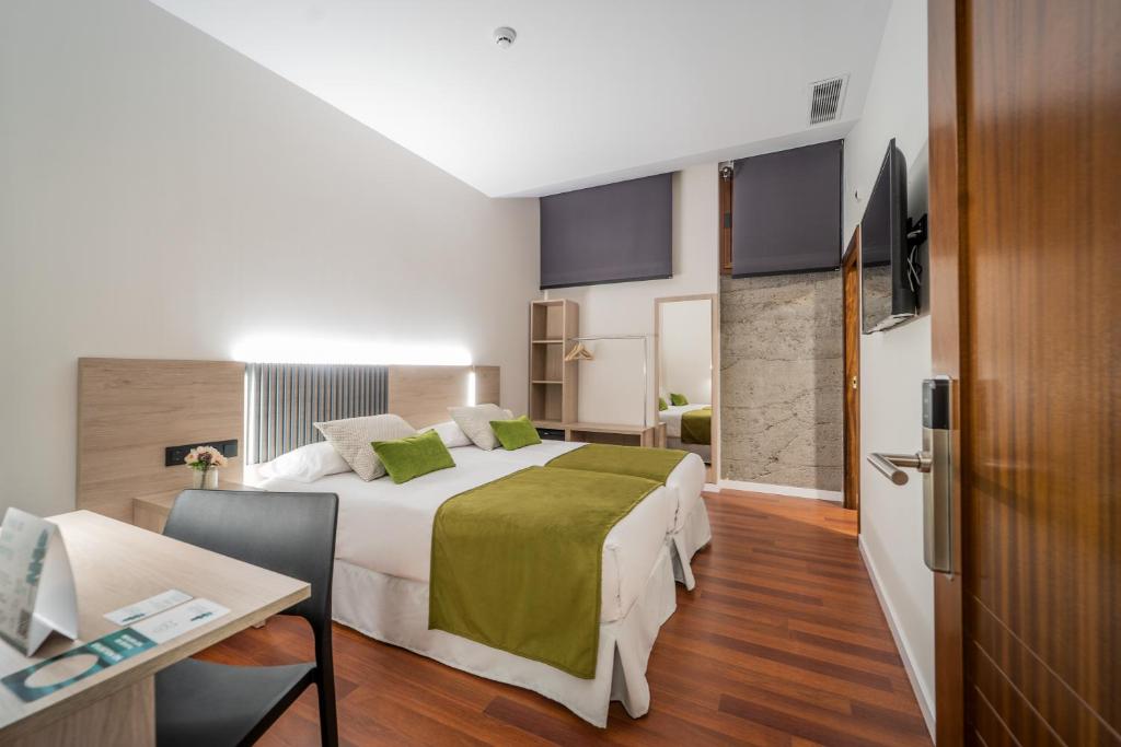 una camera d'albergo con letto, tavolo e scrivania di SAHERA HOTEL Boutique a Telde