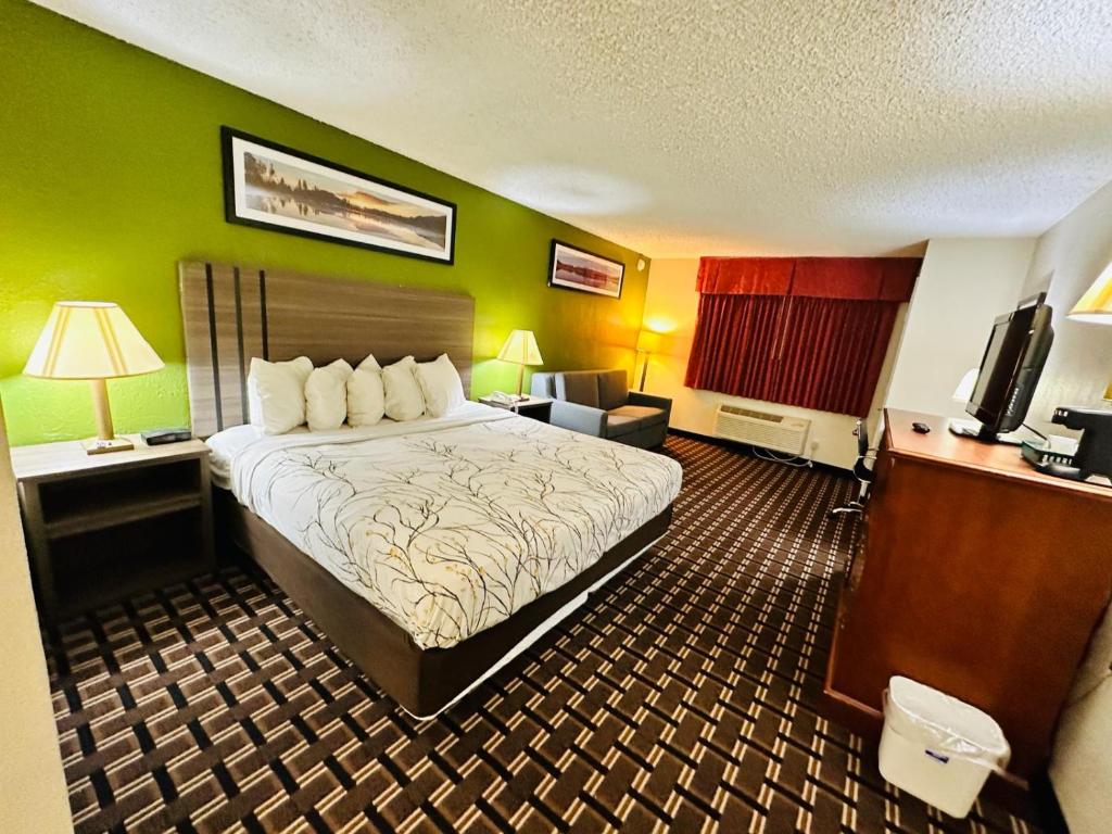 a hotel room with a large bed and a desk at Rodeway Inn Huron in Huron