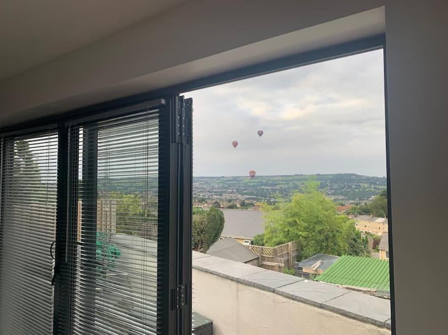okno z widokiem na balony na ciepło w oddali w obiekcie Entire Bungalow with 2 car Parking.Stunning views w mieście Bath