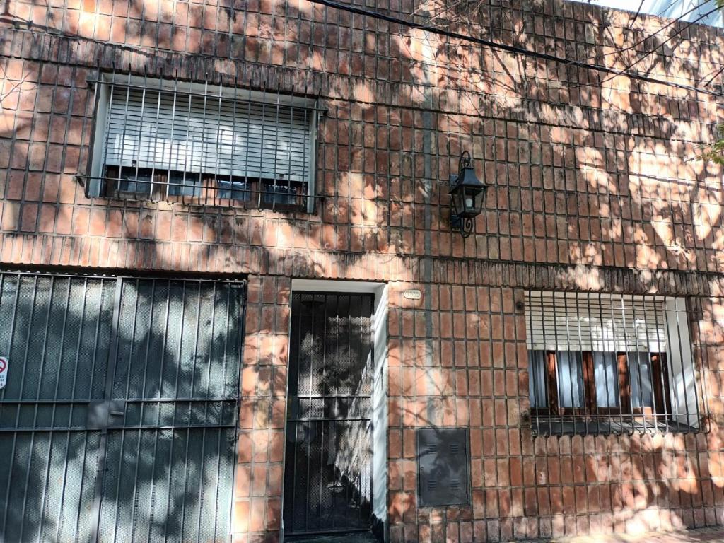 a brick building with three windows and a door at La Casa de al Lado con Garage !!! in La Plata