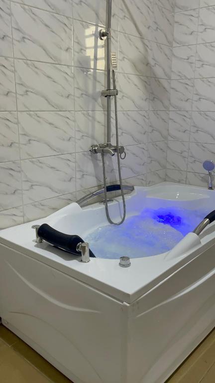 - une baignoire blanche avec douche et eau bleue dans l'établissement First Royal Beam Hotel, à Makurdu