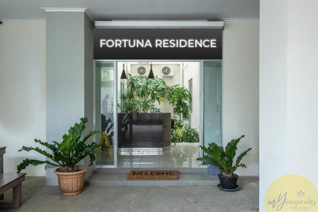 a front door of aeria residence with potted plants at Fortuna Hotel & Residence by My Hospitality in Bandung