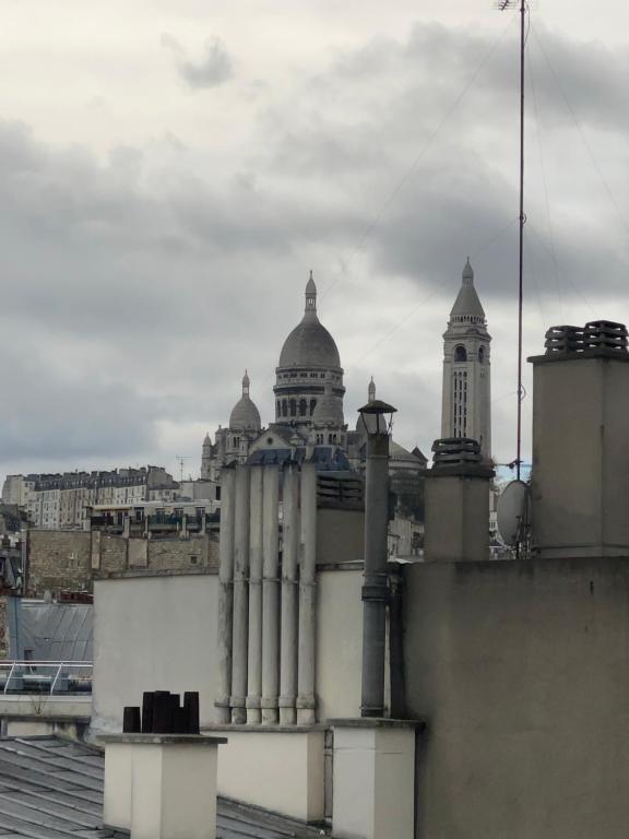 - une vue sur un bâtiment avec deux dômes au-dessus dans l'établissement Appartement cosy Paris centre Montmartre, à Paris