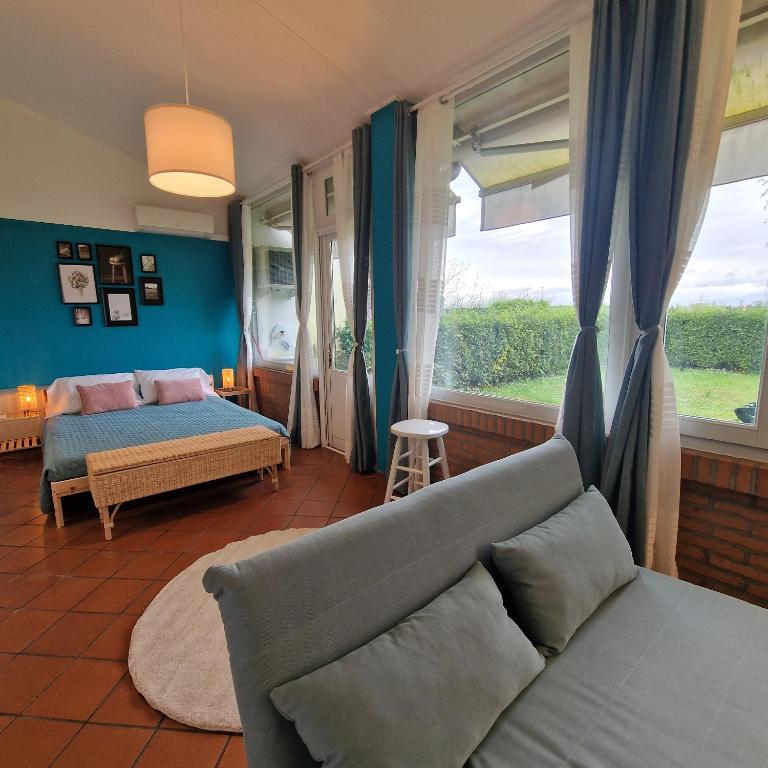 - un salon avec un canapé, un lit et une fenêtre dans l'établissement Residenza Vittoria, à Bagnolo San Vito
