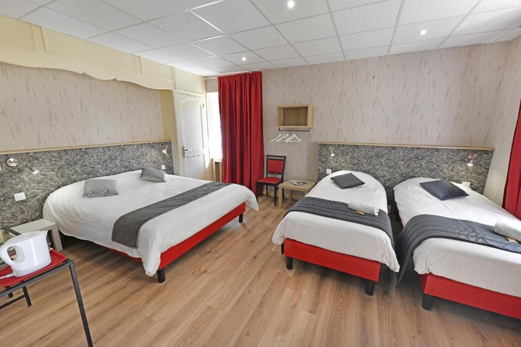 two beds in a hotel room with red curtains at Les Portes du Cantal in Massiac