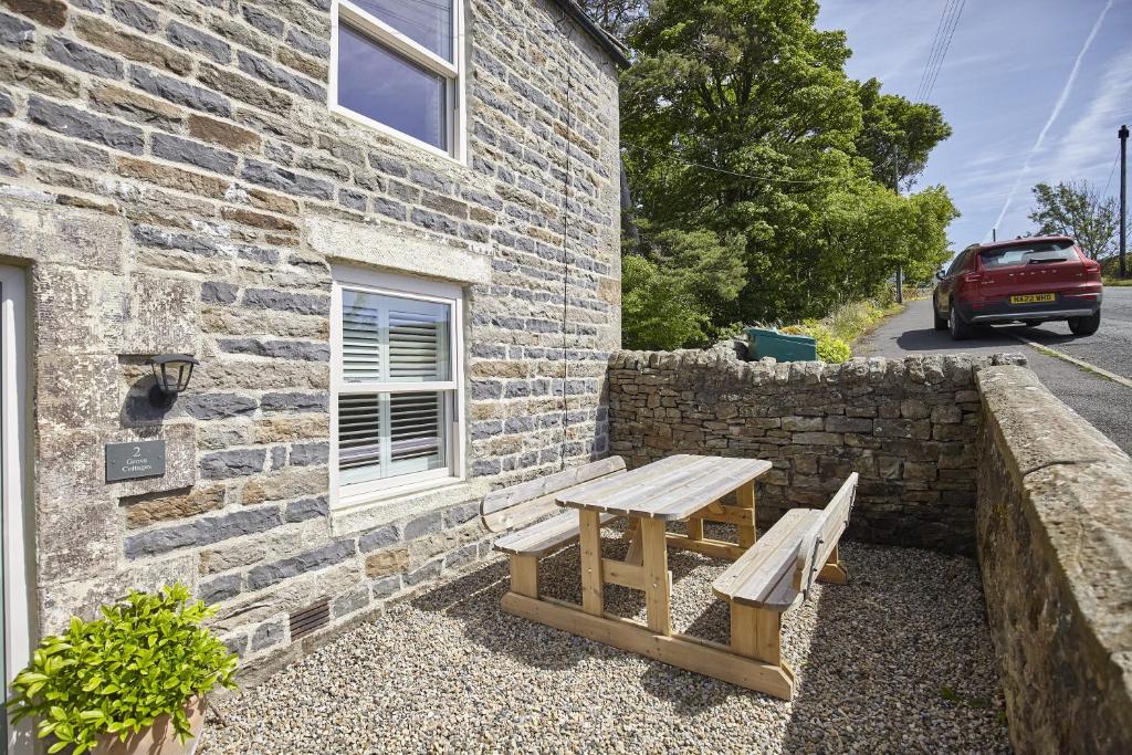 a wooden bench sitting outside of a brick building at Cumbria, en-suite bathrooms, North Pennines in Alston